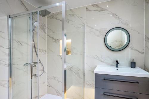 a bathroom with a shower and a sink and a mirror at Modern apartment near Wembley Stadium in London