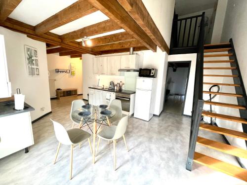 a kitchen and dining room with a glass table and chairs at Appartement La Tour in Vesoul