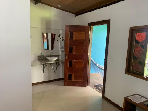 a bathroom with a door and a sink and a mirror at Pousada e Camping Lumiar in Lençóis