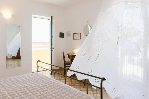 a bedroom with a bed with a veil on the wall at Hotel Signum in Malfa