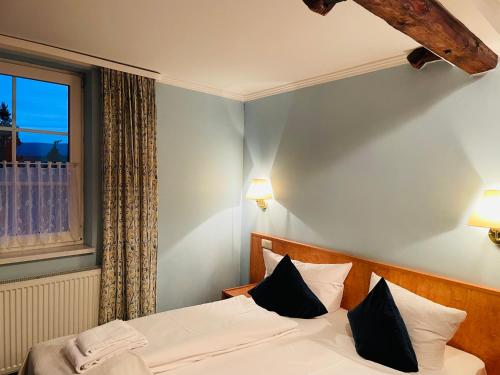 a bedroom with a bed with two pillows and a window at Harzhotel Warnstedter Krug in Thale