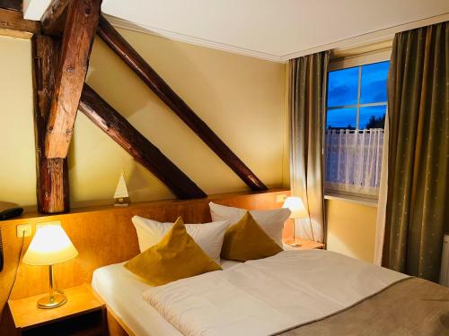 a bedroom with a bed with a large window at Harzhotel Warnstedter Krug in Thale