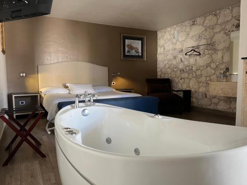 Habitación de hotel con bañera y cama en Casa Mateo Hotel Boutique, en Bernal