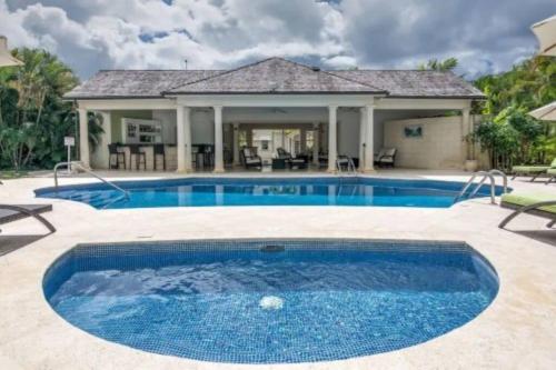 a swimming pool in a yard with a house at Blue Horizon Battaleys Mews Mullins Barbados in Saint Peter
