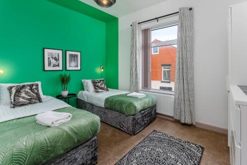 um quarto verde com duas camas e uma janela em Air Host and Stay - Hornsey Road - 5 bedroom, 4 bathroom, sleeps 10 em Liverpool