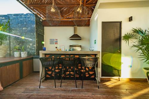 una cocina con sillas y un bar en una habitación en Emiliano 42 Condos Boutique, en Playa del Carmen