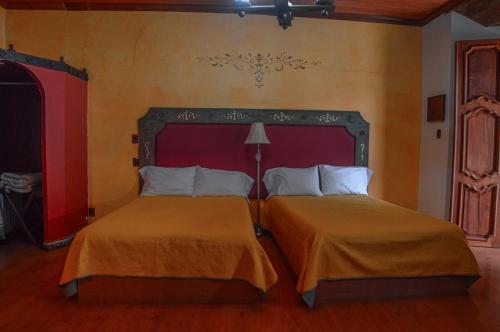 two beds in a hotel room with two beds sidx sidx sidx at Casa de los Arcángeles in San Cristóbal de Las Casas