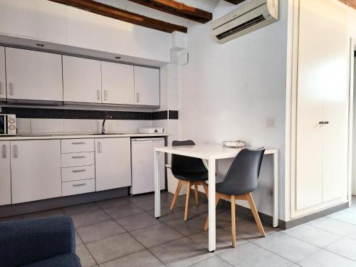 a kitchen with white cabinets and a table and chairs at Flats Friends Tetuan in Valencia