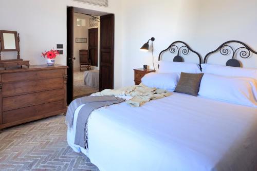 a bedroom with a large white bed and a dresser at Hotel Signum in Malfa