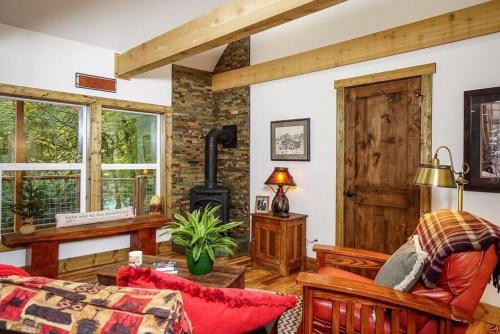 una sala de estar con estufa de leña. en Rusty Bridge River Lodge, en Granite Falls