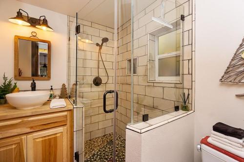 y baño con ducha, lavabo y espejo. en Rusty Bridge River Lodge, en Granite Falls