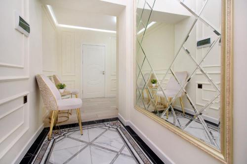 un couloir avec un miroir et une chaise dans l'établissement Прекрасные апартаменты для путешествующих семей, à Almaty