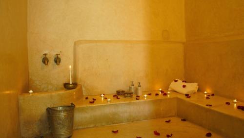 a bathroom with a tub with candles on the floor at Dar Crystal in Marrakech