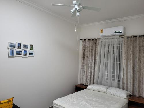 um quarto com uma cama e uma ventoinha de tecto em Lovely 2-Bed House in Accra East legon hills em Accra