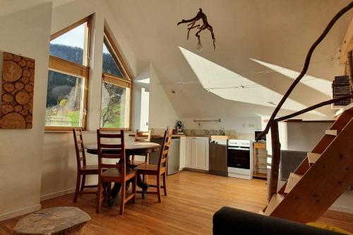 une cuisine et une salle à manger avec une table et des chaises dans l'établissement Gîte La Cochette, à Corbel