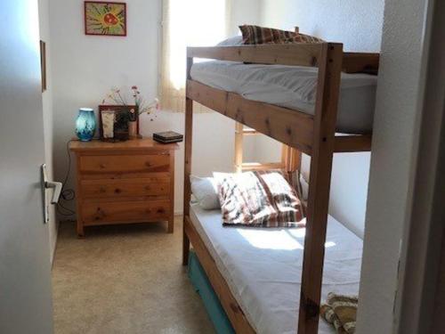 une chambre avec deux lits superposés et une commode dans l'établissement Appartement T3 en Bord de Mer à Port Barcarès - 5 Couchages, Plage à 50m, Proche Commerces - FR-1-81-205, à Port-Leucate