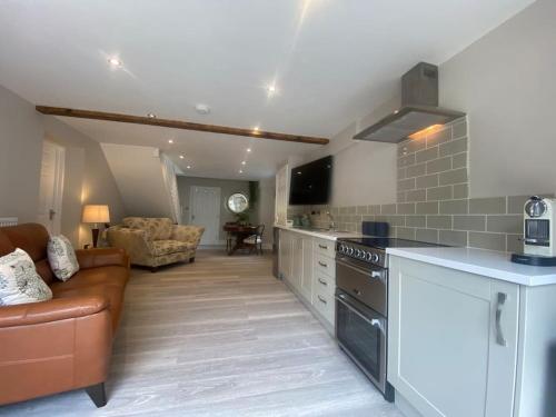 a kitchen and living room with a couch and a stove at Beautiful 1 bedroom holiday home in Lancaster in Lancaster