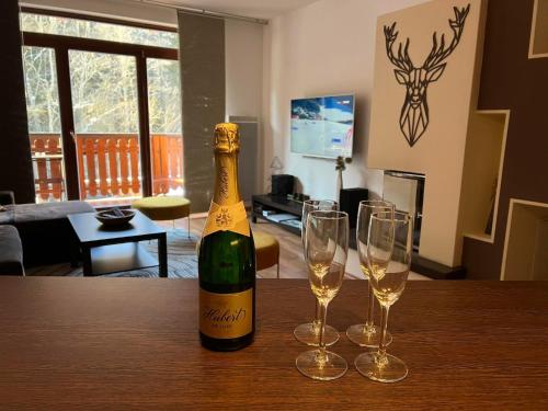 a bottle of champagne and two wine glasses on a table at Dream Apartments No.202 - Right in the heart of Tále in Tale