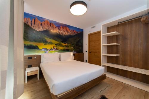 ein Schlafzimmer mit einem Bett und einem Wandgemälde in der Unterkunft YUGOGO PELLICO 8 Trento Centro in Trient