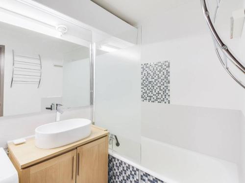 une salle de bain avec un lavabo et un miroir dans l'établissement Studio cabine pour 5 à La Mongie, pied des pistes, balcon, lave-linge - FR-1-404-104, à La Mongie