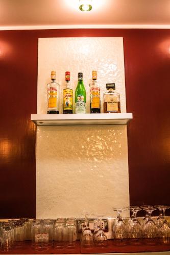 a shelf with four bottles of whiskey on it at Hotel Ginevra in Poggiomarino