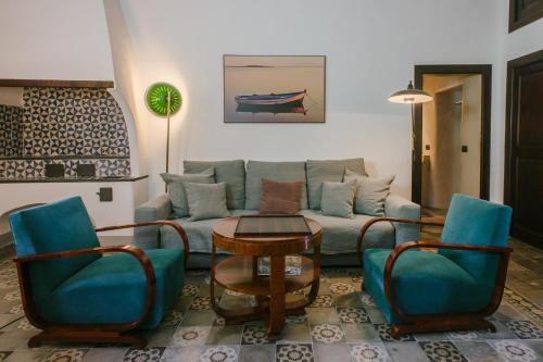 a living room with a couch and chairs and a table at Hotel Signum in Malfa