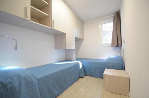 Cette petite chambre comprend 2 lits et une fenêtre. dans l'établissement Castroboleto Village, à Nova Siri Marina