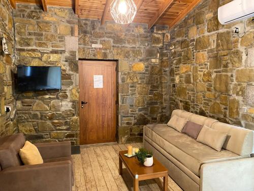 a living room with a couch and a stone wall at Caviro on the Beach in Moudhros