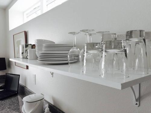 a white counter top with glasses and plates on it at LEED Platinum Green Home Getaway in Seattle