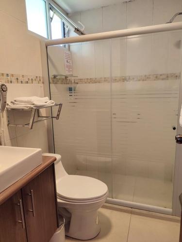 a bathroom with a toilet and a glass shower at Hotel Sumaq Kay in Cumbayá