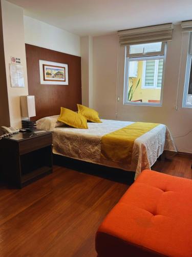 a bedroom with a bed and a desk and a window at Hotel Sumaq Kay in Cumbayá