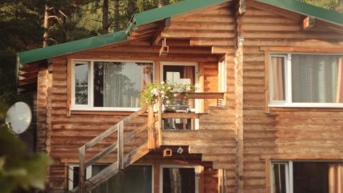 a wooden house with a staircase and windows at Petrovmotopunkt in Yaremche