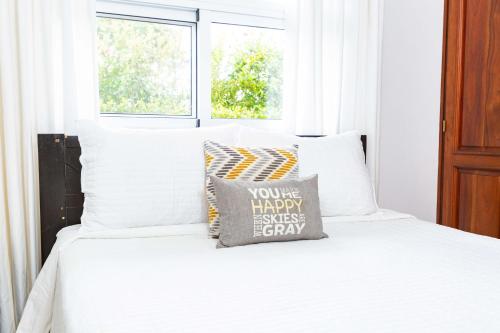 a bed with white sheets and a pillow on it at Sosua Ocean Village Properties by Calisto Stays in Sosúa