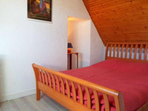 sypialnia z drewnianym łóżkiem i czerwonym kocem w obiekcie Appartement La Trinité-sur-Mer, 2 pièces, 5 personnes - FR-1-477-61 w mieście Trinité-sur-Mer