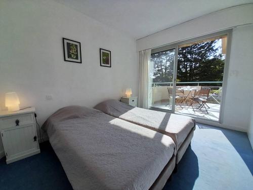 une chambre avec un lit et une grande fenêtre dans l'établissement Appartement 2 pièces avec balcon et proche plages - Carnac - FR-1-477-127, à Carnac