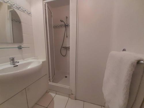 une salle de bain blanche avec une douche et un lavabo dans l'établissement Appartement 2 pièces avec balcon et proche plages - Carnac - FR-1-477-127, à Carnac