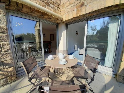 un patio avec une table et des chaises sur un balcon dans l'établissement Appartement 2 pièces avec balcon et proche plages - Carnac - FR-1-477-127, à Carnac
