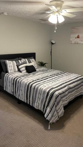 a bedroom with a bed with a black and white comforter at The Jewel of Jacksonville in Jacksonville