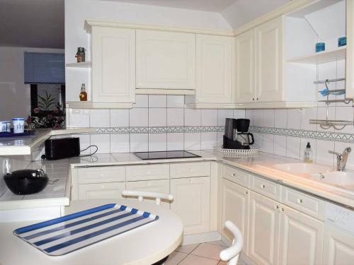 une cuisine blanche avec des armoires blanches et un évier dans l'établissement Bel Duplex 3* près de la plage, parking - Perros-Guirec - FR-1-368-144, à Perros-Guirec