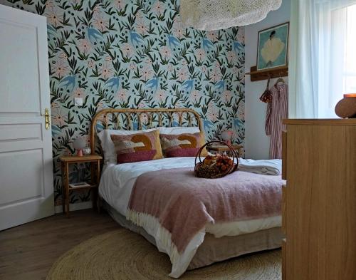 una camera da letto con un letto e carta da parati floreale di Résidence Services Séniors MONTANA CHARTRES a Chartres