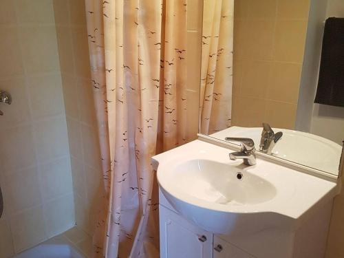 une salle de bain avec un lavabo et un rideau de douche dans l'établissement Maison climatisée avec jardin, proche plage et commerces, animaux acceptés - FR-1-494-40, à Vaux-sur-Mer