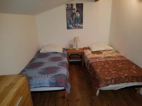 Cette chambre comprend deux lits et une table avec une photo. dans l'établissement Maison climatisée avec jardin, proche plage et commerces, animaux acceptés - FR-1-494-40, à Vaux-sur-Mer