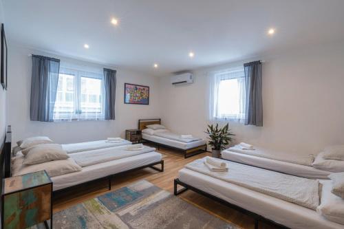ein Wohnzimmer mit mehreren Betten und einem Sofa in der Unterkunft Vibe House Prague in Prag