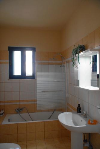 a bathroom with a bath tub and a sink at The Blue Leaf Family Villa in Gennadi