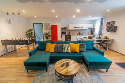 ein Wohnzimmer mit einem blauen Sofa und einem Tisch in der Unterkunft Vibe House Prague in Prag