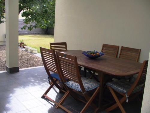 a wooden table with chairs and a bowl of fruit on it at B&B Solanas in Càbras
