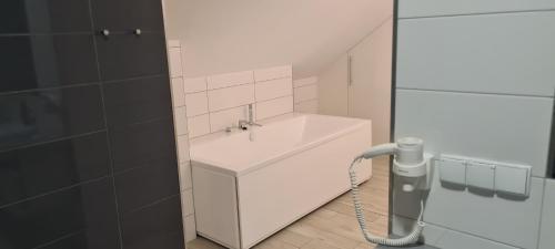 ein Badezimmer mit einem weißen Waschbecken und einer Dusche in der Unterkunft Apartament Czarna Gora B39 in Heudorf
