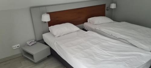 um quarto com duas camas e uma mesa de cabeceira com um telefone em Apartament Czarna Gora B39 em Sienna