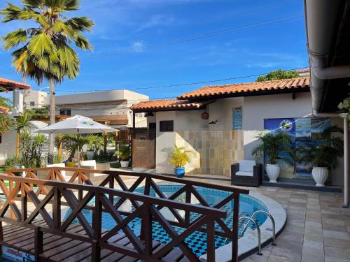 a patio with a pool and a house at Pousada Sete Mares in Barra de São Miguel