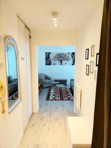 - un couloir avec un salon doté d'un canapé et d'un miroir dans l'établissement Cosy Home 1 - Spacieux 3 pièces avec parking - 30 min de Paris, à Cergy